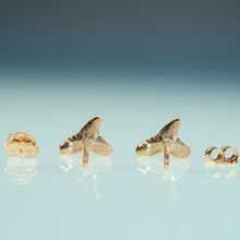 Load image into Gallery viewer, Gold shark fin earrings on a light blue background
