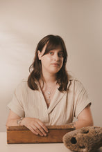 Load image into Gallery viewer, Female, Brunette, clam bar necklace, scallop with pearl necklace, small seahorse necklace, sandy, beige, neutral background