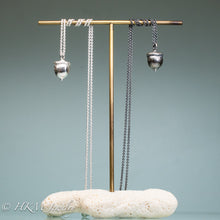 Load image into Gallery viewer, cast silver acorn necklaces on brass and coral display by hkm jewelry in oxidized and polished finish