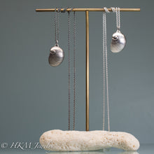 Load image into Gallery viewer, Baby's Ear Necklaces in oxidized and polished finish hanging on brass and coral jewelry display by hkm jewelry