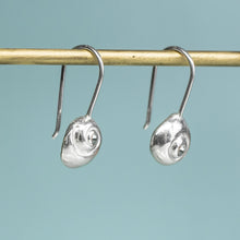 Load image into Gallery viewer, Silver earrings hanging on a rod against a light blue background