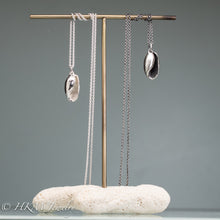 Load image into Gallery viewer, cast atlantic bubble shell necklaces in oxidized and polished sterling silver on brass and coral jewelry stand by hkm jewelry