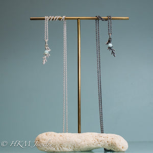 cast silver cypress bough and amazonite necklaces on brass and coral jewelry stand by hkm jewelry in polished and oxidized finish