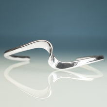 Load image into Gallery viewer, Silver wave bracelet on a gradient blue and gray background