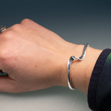 Load image into Gallery viewer, Silver bracelet on a wrist with a neutral background