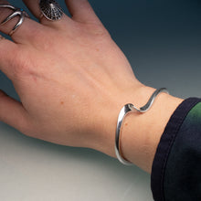 Load image into Gallery viewer, Silver bracelet on a wrist with a neutral background