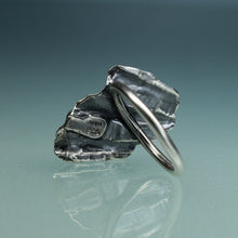 Load image into Gallery viewer, underside of silver shell textured ring with barnacle on hand model with teal gradient background