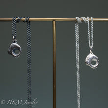 Load image into Gallery viewer, close up of hag stone necklaces cast in sterling silver by hkm jewelry in oxidized and polished finishes