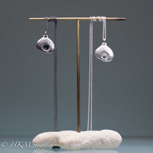 Load image into Gallery viewer, hag stone necklaces cast  in sterling silver by hkm jewelry on brass and coral jewelry stand