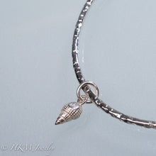 Load image into Gallery viewer, back of mud snail charm on hammered silver bangle by hkm jewelry
