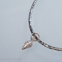 Load image into Gallery viewer, back of mud snail charm on hammered silver bangle by hkm jewelry