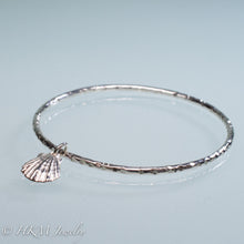 Load image into Gallery viewer, hammered silver bangle with lion's paw scallop shell charm by hkm jewelry