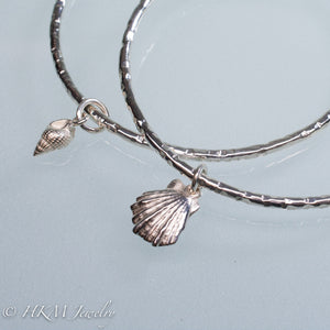 hammered silver bangles with mud snail and lion's paw shell charms by hkm jewelry