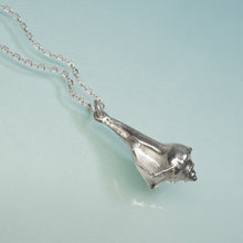 Load image into Gallery viewer, Silver conch shell pendant on a chain against a light blue background