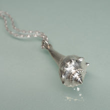 Load image into Gallery viewer, Silver seashell pendant on a chain against a light blue background