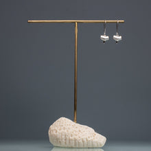 Load image into Gallery viewer, cast silver small shark tooth earrings on brass and coral earring stand with blue gradient background