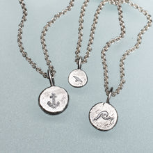 Load image into Gallery viewer, Three silver necklaces with engraved pendants on a light blue background