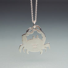 Load image into Gallery viewer, Silver crab-shaped pendant on a chain against a gray background