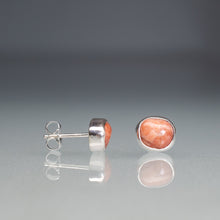 Load image into Gallery viewer, Pair of silver earrings with pink stone on a reflective surface