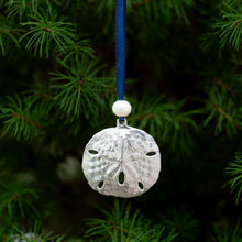 Load image into Gallery viewer, close up of cast silver sand dollar ornament from stone harbor nj with freshwater pearl and navy blue satin ribbon by hkm jewelry on evergreen tree