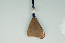 Load image into Gallery viewer, Bronze pendant on a blue cord with a pearl bead against a light gray background