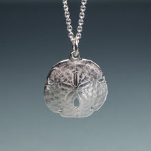 Load image into Gallery viewer, small silver sand dollar shell necklace on cable chain with blue gradient background