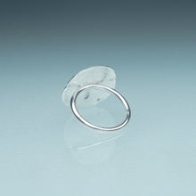 Load image into Gallery viewer, underside view of silver sand dollar ring on blue green gradient background
