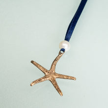Load image into Gallery viewer, back view of cast bronze starfish ornament with freshwater pearl and navy blue satin ribbon by hkm jewelry