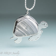 Load image into Gallery viewer, hand sawn and pierced sterling silver sea turtle necklace with fossilized clam shell shard bezel setting
