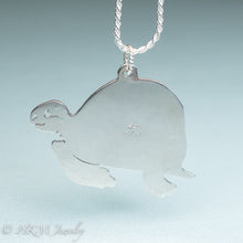 Load image into Gallery viewer, back side of hand sawn and pierced sterling silver sea turtle necklace with fossilized clam shell shard bezel setting