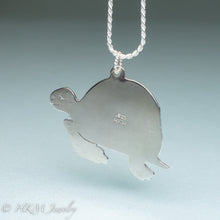Load image into Gallery viewer, underside of hand sawn and pierced sterling silver sea turtle necklace with fossilized clam shell shard bezel setting by hkm jewelry stamped 925