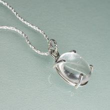 Load image into Gallery viewer, Silver necklace with a clear pendant on a light blue background