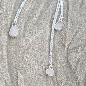 small medium and large raw cape may diamond necklaces in sterling bezels by hkm jewelry laying in sand