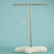 Load image into Gallery viewer, 3 little clams bar necklace on coral and brass stand