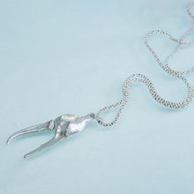 Load image into Gallery viewer, underside view of the cast fiddler crab claw necklace in recycled silver laying on a blue background by hkm jewelry