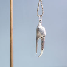 Load image into Gallery viewer, close up view of the cast fiddler crab claw necklace in recycled silver hanging from brass and coral necklace display on a blue background by hkm jewelry