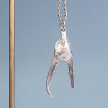 Load image into Gallery viewer, underside view of the open pincer of the cast fiddler crab claw necklace in recycled silver hanging from brass and coral necklace display on a blue background by hkm jewelry