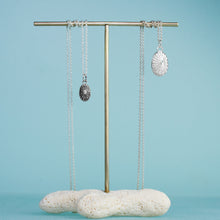 Load image into Gallery viewer, large and small silver keyhole limpet shell necklaces on brass and coral display by hkm jewelry