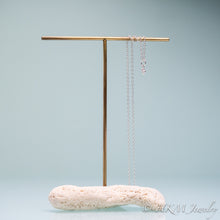 Load image into Gallery viewer, mini conch seashell necklace cast in silver by hali maclaren of hkm jewelry on a brass and coral t bar necklace stand