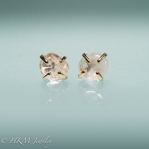 close up front view of medium size prong set tumble polished cape may diamond stud earrings in 14k yellow gold by hkm jewelry