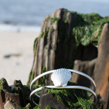 Load image into Gallery viewer, cast silver bay scallop shell cuff laying on driftwood by the shoreline in cape may by hkm jewelry hali maclaren