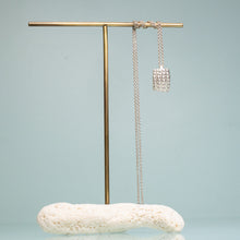 Load image into Gallery viewer, cast silver urchin test shard in recycled silver on coral and brass jewelry stand by hkm jewelry