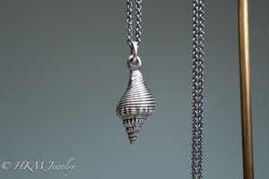 back view of fl fighting conch shell necklace in oxidized sterling silver  by hkm jewelry