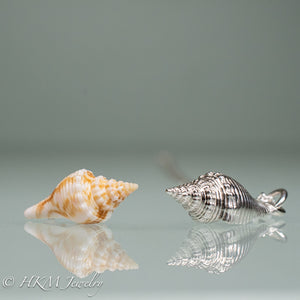 side view of fl fighting conch shell and cast silver replica by hkm jewelry