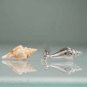side view of fl fighting conch shell and cast silver replica with HKM makers mark and hallmark 925 stamps by hkm jewelry