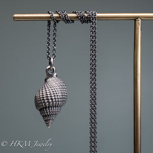 back view of cast silver nutmeg shell necklace in an oxidized finish by hkm jewelry