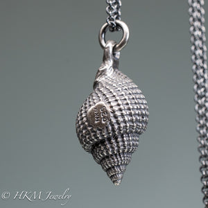 close up view of hallmark 925 and makers mark on cast silver nutmeg shell necklace in an oxidized finish by hkm jewelry