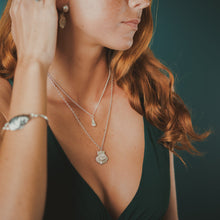 Load image into Gallery viewer, Female, red-head, sea tail ring, limpet ring, lion’s paw pearl earrings, marginella necklace, lion’s paw necklace, oyster seed cuff, green/blue, teal, underwater background
