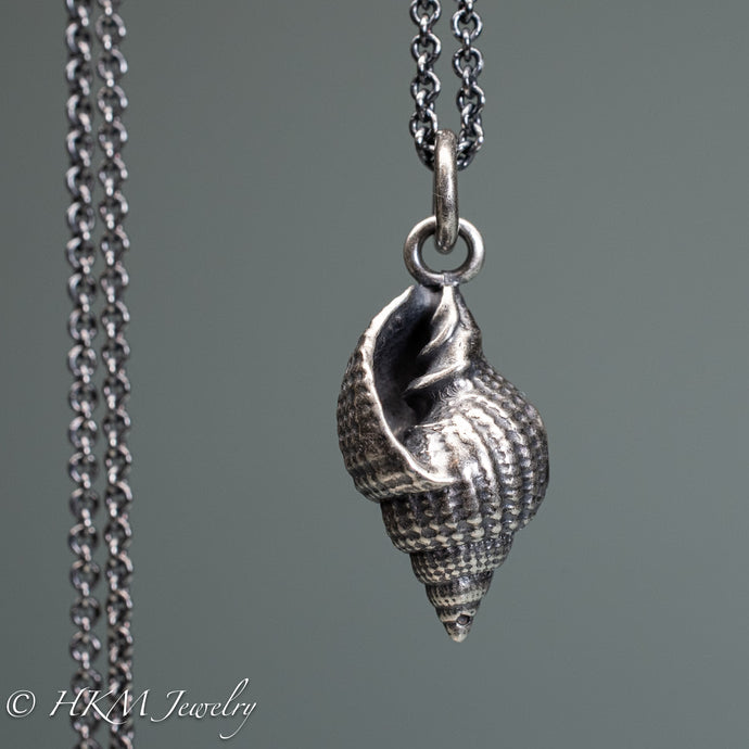 close up front view cast silver nutmeg shell necklace in an oxidized finish by hkm jewelry