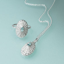Load image into Gallery viewer, Silver ring and pendant set with aquamarine stones on a light blue background
